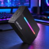 Schwarze FIFINE AmpliGame V3 Capture Card mit RGB-Beleuchtung auf einem Gaming-Schreibtisch